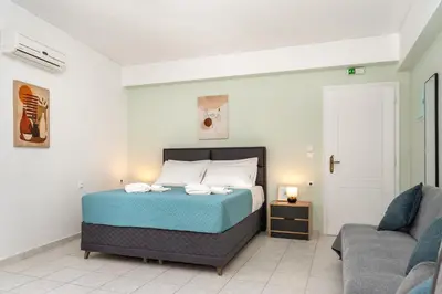 a bedroom with a bed and a couch at Manoli's Studios Old Town Chania in Chania Town