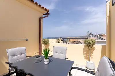 a table and chairs on a balcony with a view at Manoli's Studios Old Town Chania in Chania Town