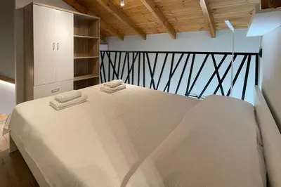 a bedroom with a large white bed with towels on it at LOFTaki - Petite house next to Koum Kapi beach in Chania Town