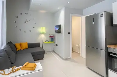 a living room with a couch and a refrigerator at LOFTaki - Petite house next to Koum Kapi beach in Chania Town