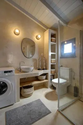 a bathroom with a toilet and a sink and a washing machine at Metoxaki in Dhaskalianá
