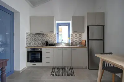 a kitchen with white cabinets and a sink at Metoxaki in Dhaskalianá
