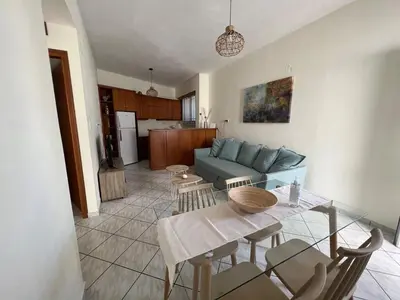 a living room with a table and a blue couch at Aria Aparment in Palaiochóra