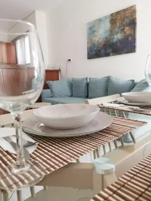 a table with a wine glass and plates on it at Aria Aparment in Palaiochóra