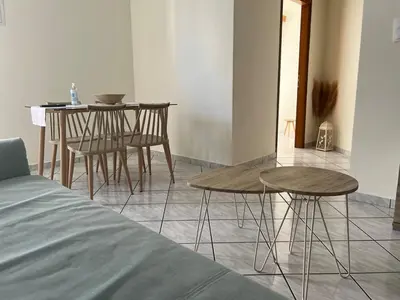 a room with two tables and a table and chairs at Aria Aparment in Palaiochóra