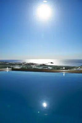 a swimming pool with the ocean in the background at Fotini Traditional Villas in Kavoúsion
