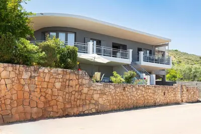 a large house behind a stone wall at Solena in Tsikalariá