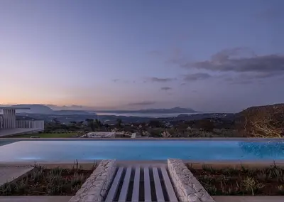 a swimming pool with a sunset in the background at Nature & Beauty Villa in Xirostérnion