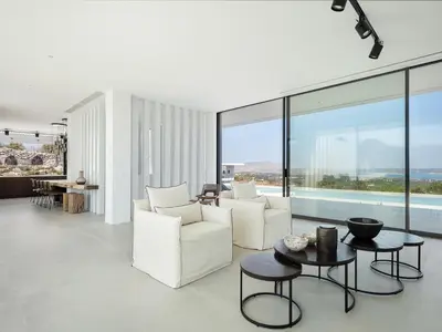a living room with white furniture and large windows at Nature & Beauty Villa in Xirostérnion