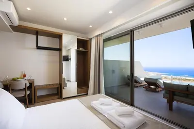 a bedroom with a view of the ocean at Mouria Luxury Suites - Adults Only in Falasarna