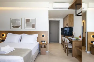 a hotel room with a bed and a kitchen at Mouria Luxury Suites - Adults Only in Falasarna