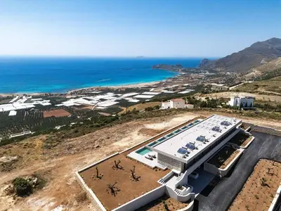 an aerial view of a building with a pool and the ocean at Mouria Luxury Suites - Adults Only in Falasarna