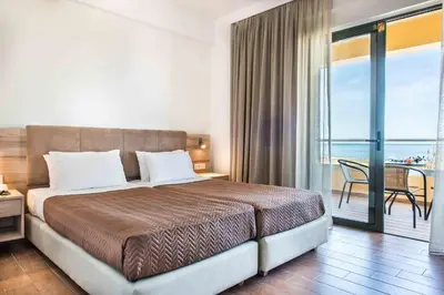 a bedroom with a large bed and a balcony at Gerona Mare Apartments in Gerani Chanion