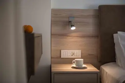 a coffee cup on a table next to a bed at Gerona Mare Apartments in Gerani Chanion
