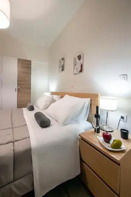 a bedroom with a large white bed and a table with a plate of fruit at Perivolia Panorama - Peaceful Retreat with View in Perivólia