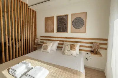a bedroom with a bed with white sheets and pillows at Καλαίσθητο Ηλιόλουστο Studio in Chania Town