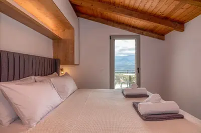 a bedroom with a large bed with a large window at Aptera Verde - Stone Cottages Complex in Áptera