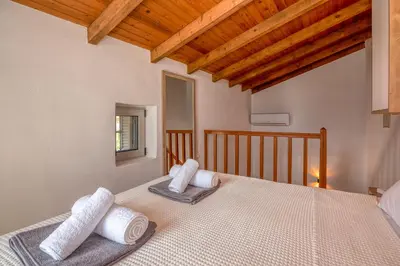 a bedroom with a bed with white towels on it at Aptera Verde - Stone Cottages Complex in Áptera