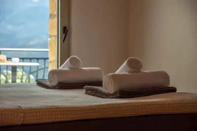 two towels sitting on top of a bed at Aptera Verde - Stone Cottages Complex in Áptera