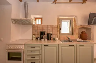 a kitchen with white cabinets and a sink at Aptera Verde - Stone Cottages Complex in Áptera