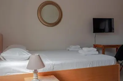 a bedroom with a bed with a mirror and a television at Roidis Apartments -close to city in Chania Town