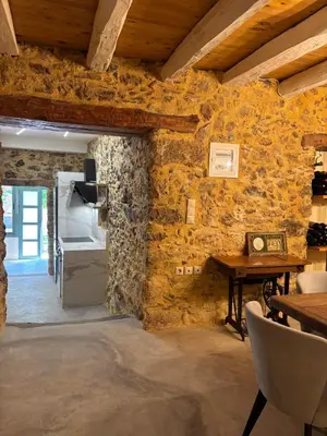 a room with a stone wall with a table and chairs at Nature dream 1833 in Dhrakóna