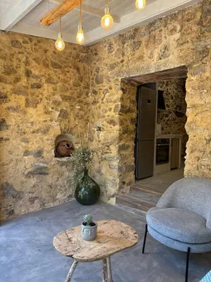 a room with a stone wall with a chair and a table at Nature dream 1833 in Dhrakóna