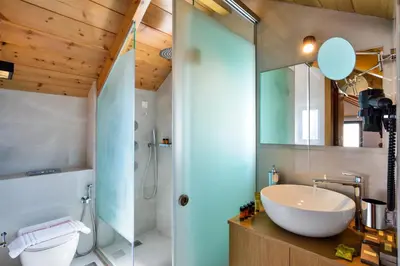 a bathroom with a glass shower and a sink at Elia Agia Marina Hotel in Agia Marina Nea Kydonias