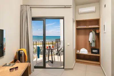a room with a balcony with a view of the ocean at Elia Agia Marina Hotel in Agia Marina Nea Kydonias