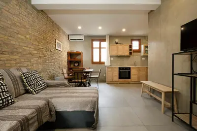 a living room with a couch and a brick wall at Rianou Apartment in Chania Town