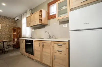 a kitchen with wooden cabinets and a white refrigerator at Rianou Apartment in Chania Town