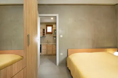 a small bedroom with two beds and a kitchen at Rianou Apartment in Chania Town