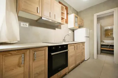 a kitchen with wooden cabinets and a black appliance at Rianou Apartment in Chania Town