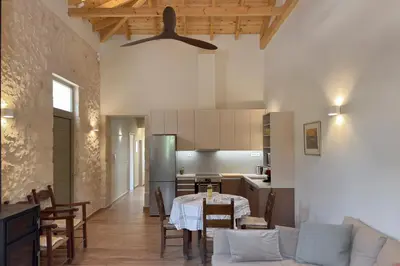 a living room with a table and a kitchen at Lithos Residence in Chania Town