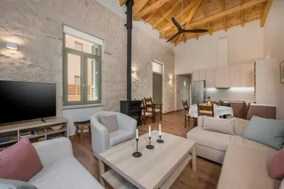 a living room with white furniture and a flat screen tv at Lithos Residence in Chania Town