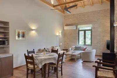 a living room with a table and chairs and a couch at Lithos Residence in Chania Town