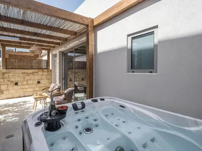 a jacuzzi tub in a living room at Vanilla Suites with Hot Tub in Daratso