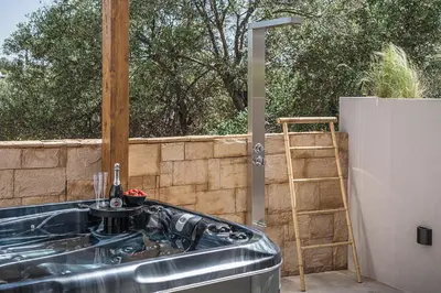 a kitchen with a stainless steel sink and a ladder at Vanilla Suites with Hot Tub in Daratso