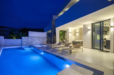 a villa with a swimming pool at night at Bella Casa - Newly Built Designer Villa in Kalyves