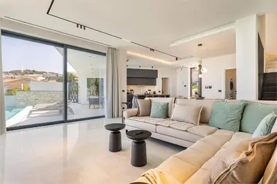 a living room with a large couch and a kitchen at Bella Casa - Newly Built Designer Villa in Kalyves