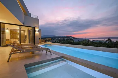 a house with a swimming pool with a sunset at Bella Casa - Newly Built Designer Villa in Kalyves