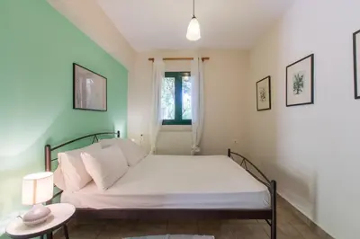 a bedroom with a white bed and a window at Ellie Villa in Tersanas