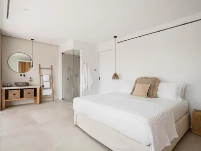 a white bedroom with a large bed and a mirror at Amazing Sea View Villa in Gavalochori