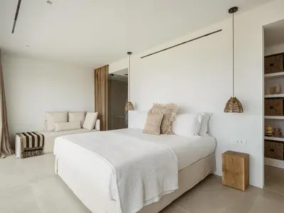 a white bedroom with a large bed and a mirror at Amazing Sea View Villa in Gavalochori