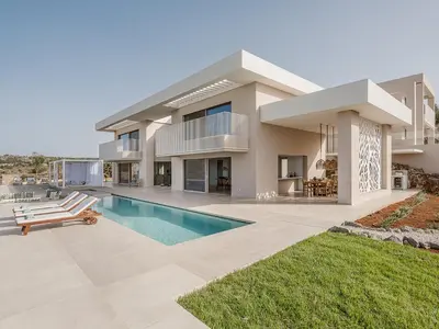 a large house with a swimming pool in front of it at Amazing Sea View Villa in Gavalochori
