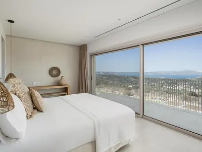 a bedroom with a white bed and a large window at Amazing Sea View Villa in Gavalochori