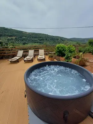 a hot tub on a deck with lounge chairs at Olive Stone in Kamisianá