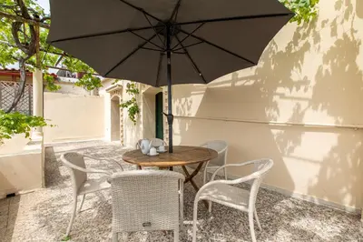 a table and chairs with an umbrella on a patio at The Orestis Old Cottage House in Stalos