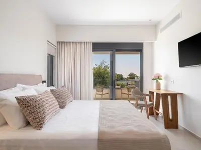 a bedroom with a bed and a desk with a television at Villa Thimi - Luxury Family Villa - Private Pool in Korakiaí