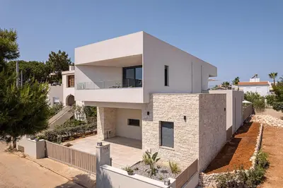 a large white house with a stone facade at Villa Thimi - Luxury Family Villa - Private Pool in Korakiaí
